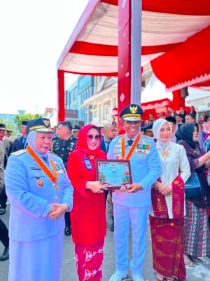 Gubernur Sulawesi Tengah Dr. H. Anwar Hafid, M.Si. menyerahkan penghargaan kepada Direktur Utama Bank Sulteng Hj. Ramiyatie.