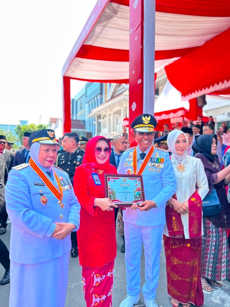 Gubernur Sulawesi Tengah Dr. H. Anwar Hafid, M.Si. menyerahkan penghargaan kepada Direktur Utama Bank Sulteng Hj. Ramiyatie.